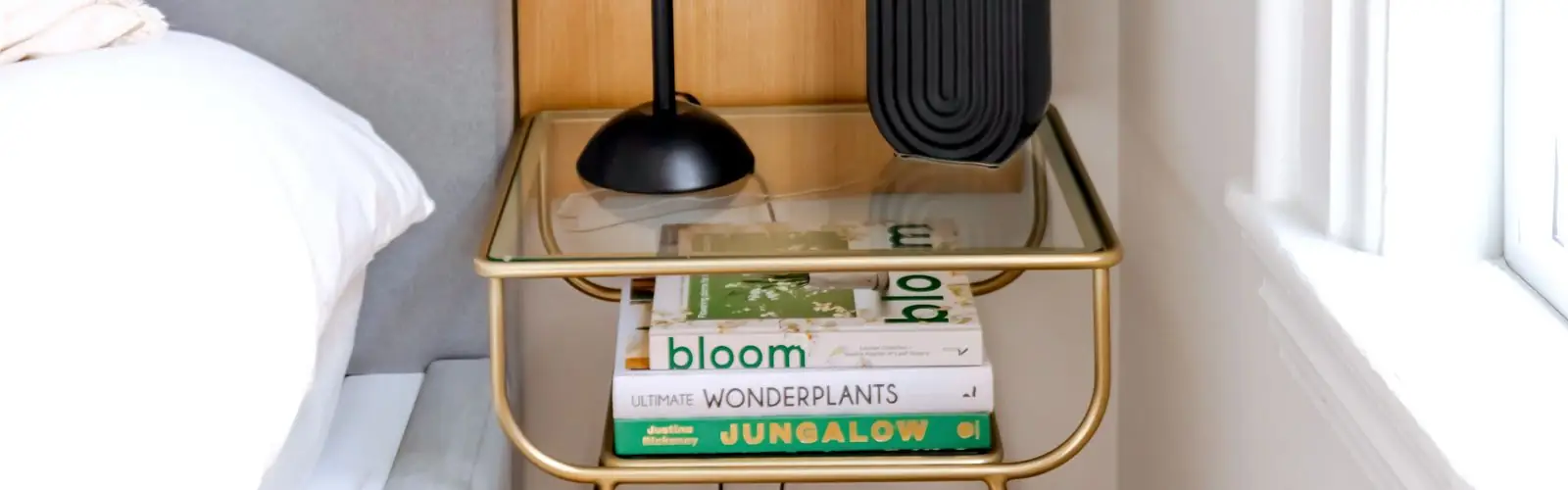 Table de chevet avec lampe et livres dans une chambre