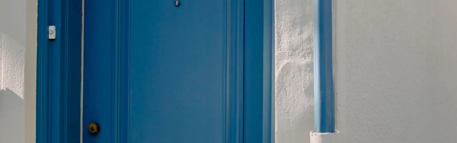 Porte d'entrée bleue d'appartement avec judas et poignée